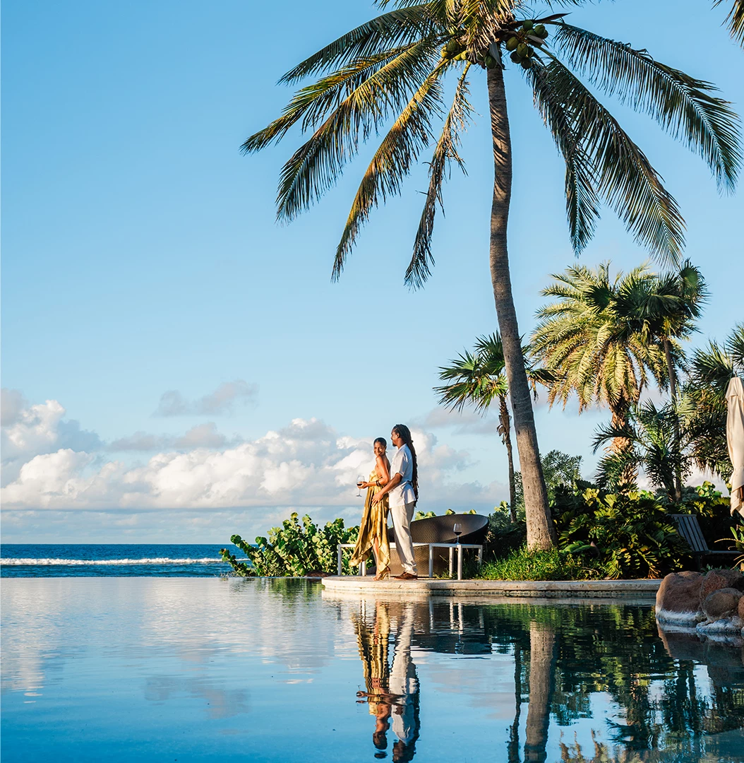 Couple embracing on a tropical beach shoreline at golden hour